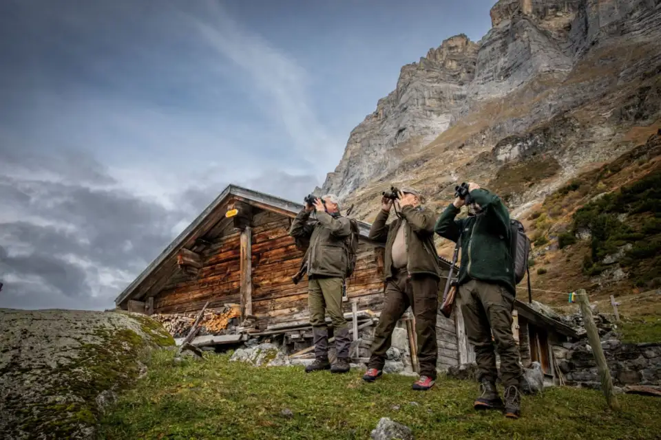 Porträt Dres Huber, Otto von Weissenfluh und Chingel Graber vor der Jagdhütte